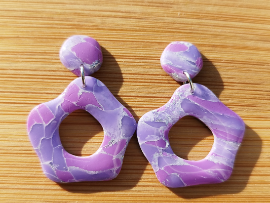 Abstract Flower in Lilac, Levander with Silver sparkles colour, Handmade Polymer Clay Earrings. The base of the Earrings is an abstract convex polygon attached to a jump ring to the Abstract Flower shape hanging from it.