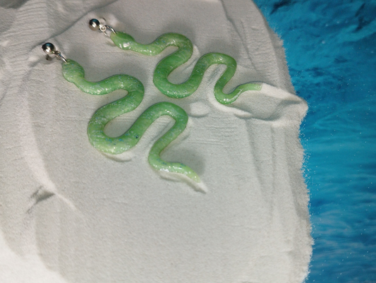 Snake shape Handmade Polymer Clay Earrings in a light green colour with silver sparkles covered with UV Resin..