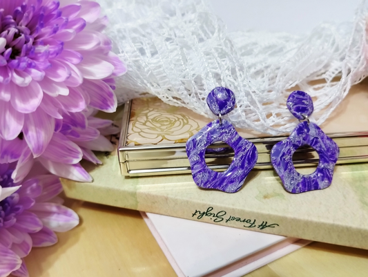 Abstract Flower in Violet with Silver sparkles colour, Handmade Polymer Clay Earrings. The base of the Earrings is an abstract convex polygon attached to a jump ring to the Abstract Flower shape hanging from it.