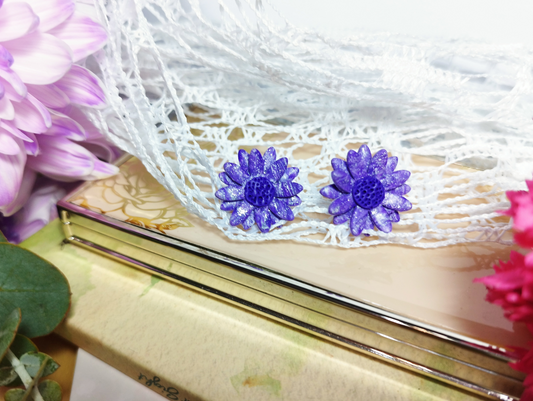 Daisy in Violet and Iris Studs, Handmade Polymer Clay Earrings. The shape of the earrings is two Daisies together in Violet and Iris colour with a circle with embossing in it in Violet colour.